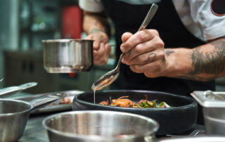 Secret recipe: Close up photo of chef hands with several tattoos